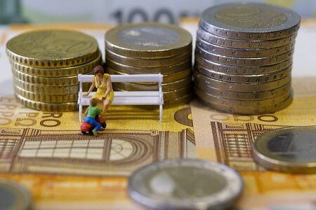 Bunch of coins with toys representing a mum and a kid